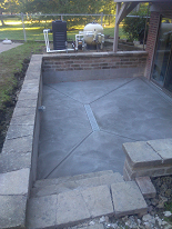 New concrete patio w/ trench drain installation & rebuilt retaining walls